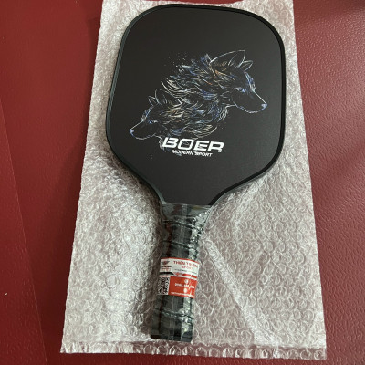 Vợt Pickleball PK03 nặng 220g, bề mặt dày 14mm từ sợi carbon, màu đen huyền bí cùng hình in nhiệt sắc nét đạt tiêu chuẩn kỹ thuật của USAPA chấp thuận để sử dụng trong thi đấu.
